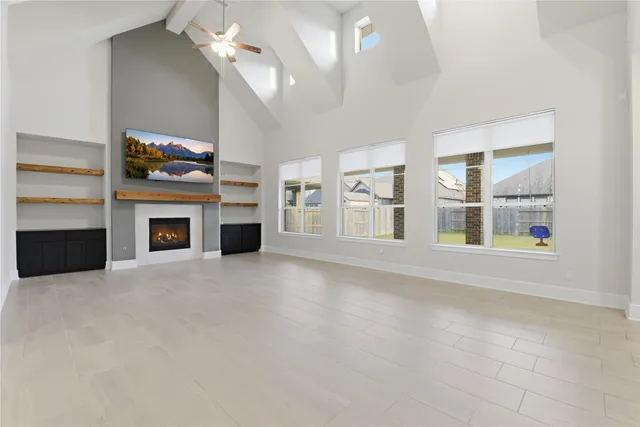 a view of an empty room with a fireplace and a window