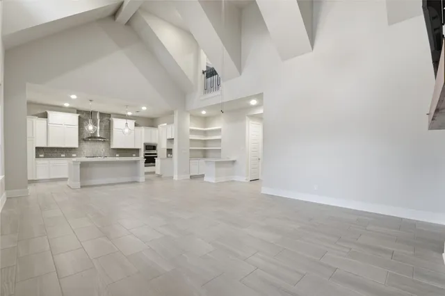 a view of large kitchen with white cabinets and stainless steel appliances