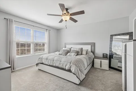 a bedroom with a bed and a large window