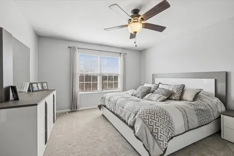 a bedroom with a large bed chandelier and a window