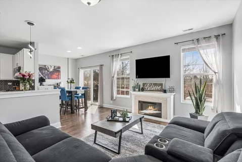 a living room with furniture a fireplace and a flat screen tv