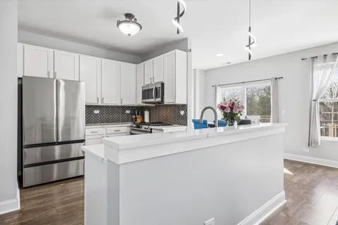 a kitchen with kitchen island a sink stainless steel appliances and cabinets