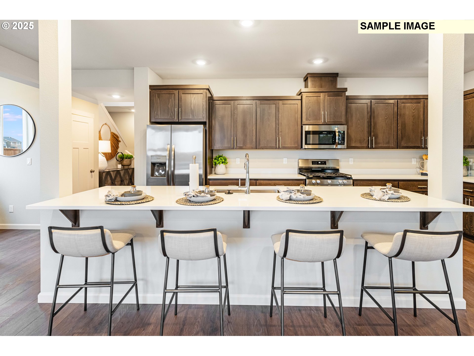 8921 Southwest Choke Cherry Tualatin, OR 97062 - Photo 5 of 28 a kitchen with stainless steel appliances kitchen island granite countertop a sink and cabinets