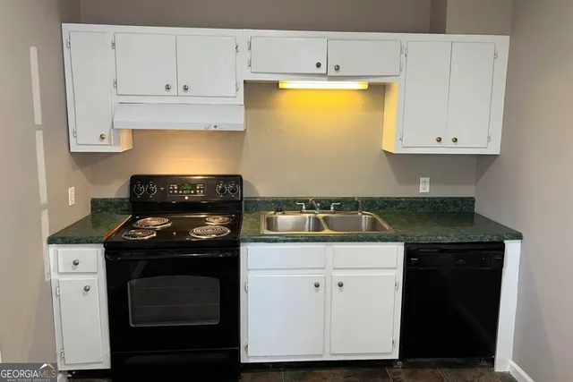a kitchen with a stove and white cabinets