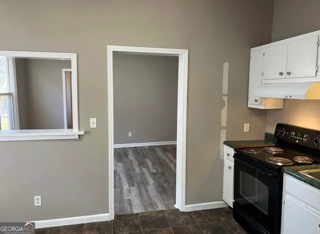 a kitchen with white cabinets and a stove