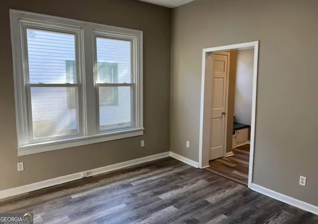 an empty room with wooden floor and a window