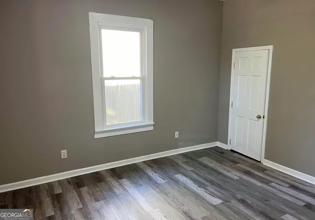 a view of a room with wooden floor and window