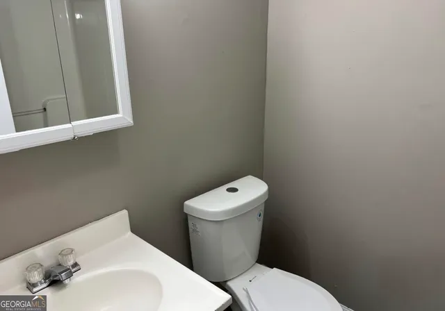 a white toilet sitting next to a white sink