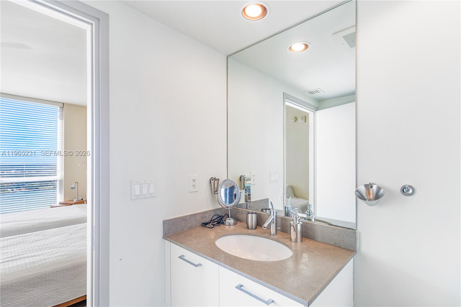 450 Alton Road, Unit 3703 Miami Beach, FL 33139 - Photo 20 of 27 a bathroom with a sink vanity granite and a mirror