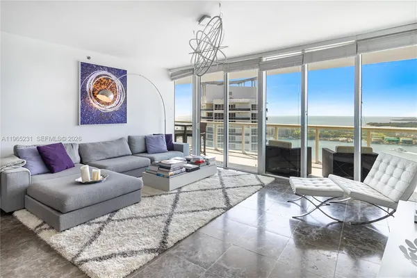 a living room with furniture and a floor to ceiling window