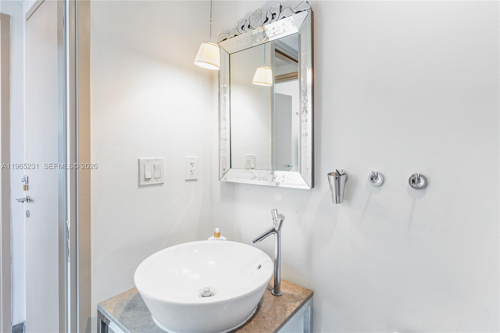 450 Alton Road, Unit 3703 Miami Beach, FL 33139 - Photo 23 of 27 a bathroom with a sink a mirror and a toilet