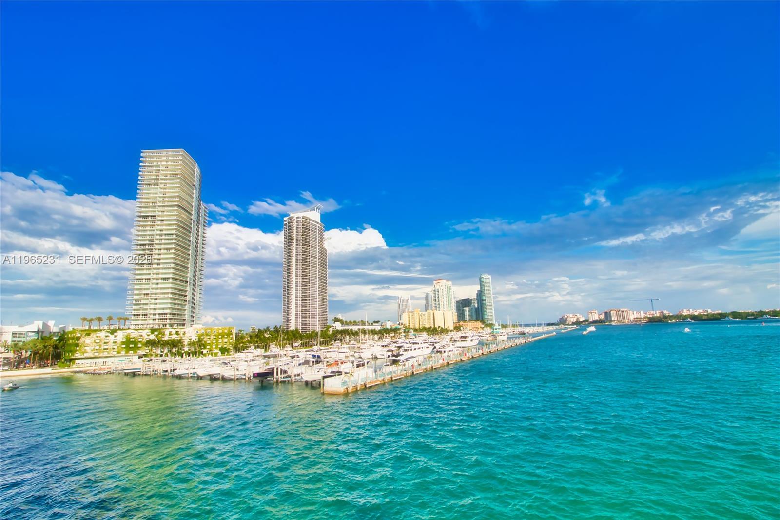 450 Alton Road, Unit 3703 Miami Beach, FL 33139 - Photo 27 of 27 a swimming pool with lawn chairs and wooden fence
