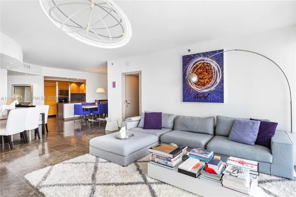 a living room with furniture and a dining table with wooden floor