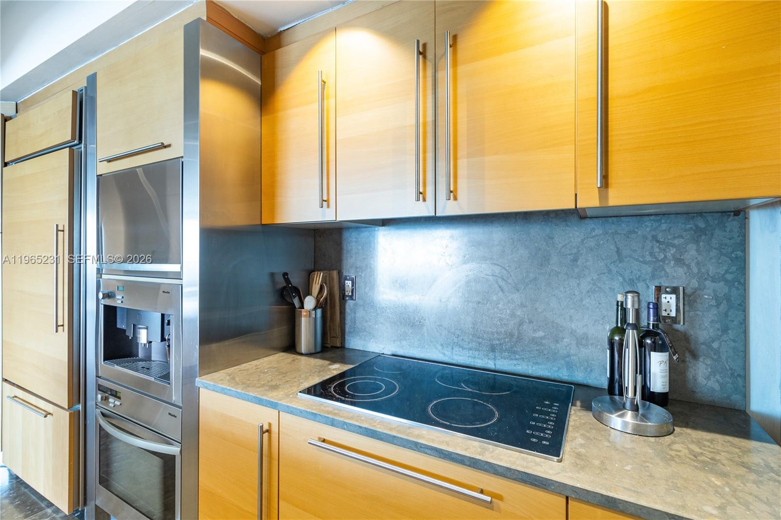 450 Alton Road, Unit 3703 Miami Beach, FL 33139 - Photo 9 of 27 a kitchen with a sink and a refrigerator