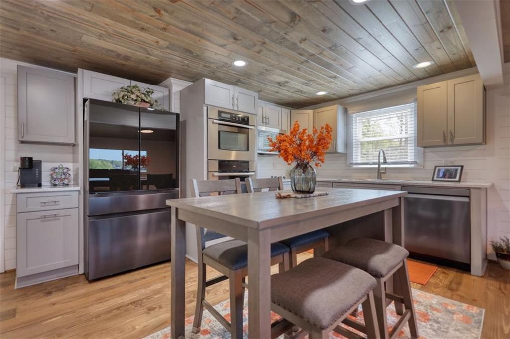 480 Friar Tuck Circle Covington, GA 30014 - Photo 11 of 56 a kitchen with stainless steel appliances kitchen island granite countertop a sink cabinets and wooden floor