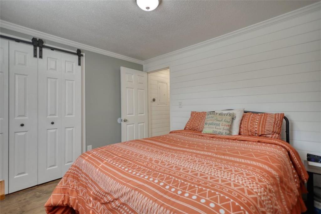 480 Friar Tuck Circle Covington, GA 30014 - Photo 19 of 56 a bedroom with a large bed and a chandelier