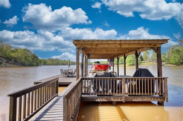 a view of swimming pool with a table and chairs under an umbrella