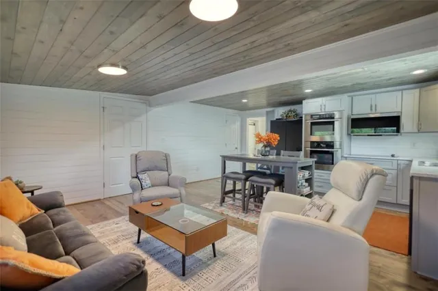 a kitchen with stainless steel appliances kitchen island granite countertop a sink cabinets and wooden floor