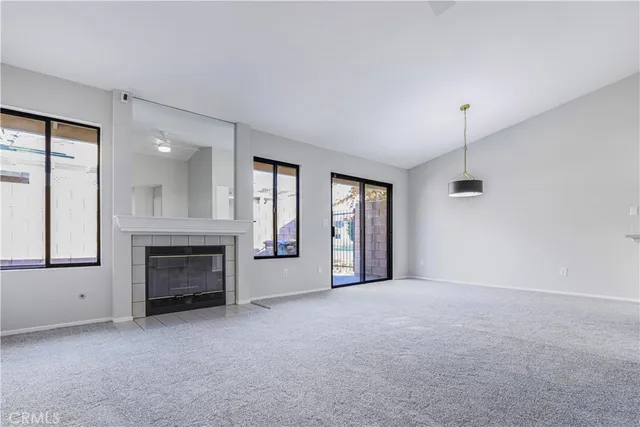 a view of empty room with a fireplace and window