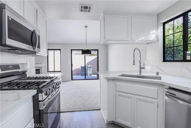 a kitchen with stainless steel appliances a sink stove and cabinets