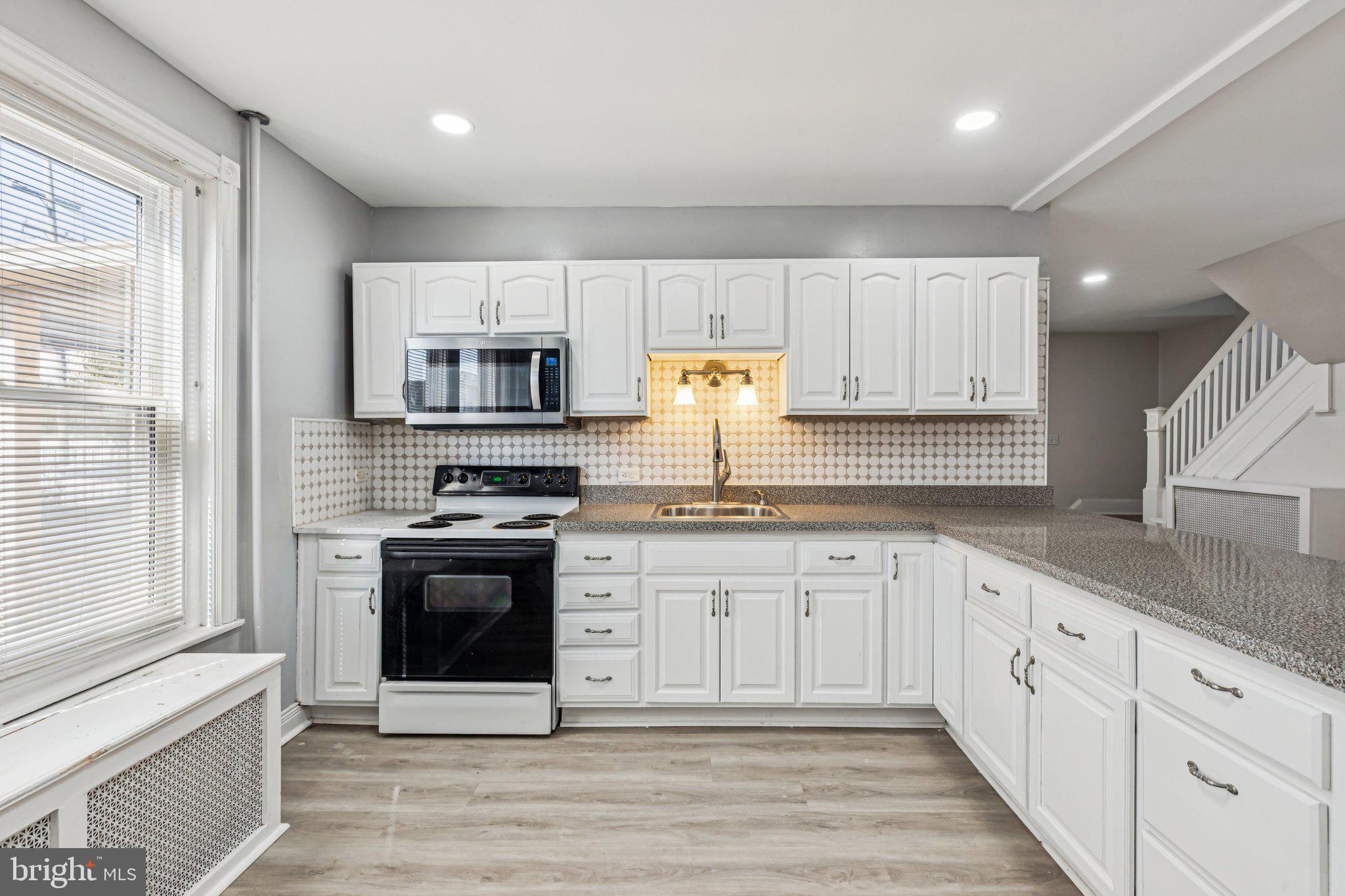 3408 Marshall Road Drexel Hill, PA 19026 - Photo 20 of 28 a kitchen with granite countertop white cabinets stainless steel appliances and a window