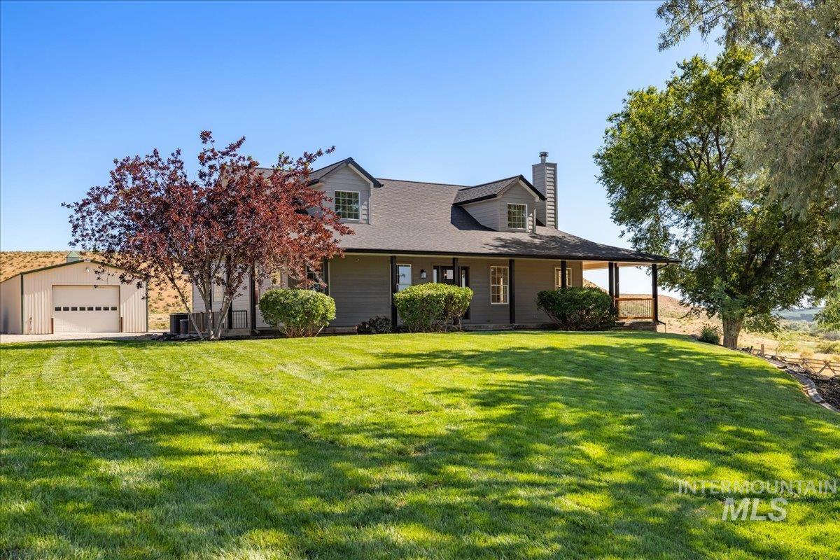 1006 Hill Road Homedale, ID 83628 - Photo 1 of 1 View of front of house with a detached garage, a chimney, and a front yard