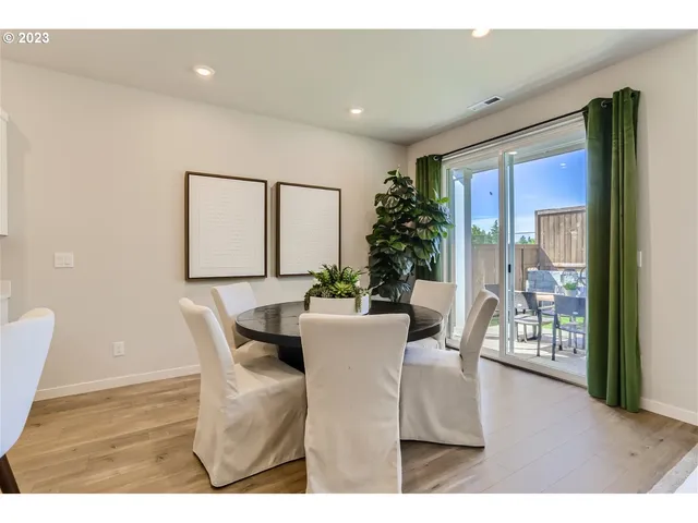 a living room with furniture a large window and wooden floor