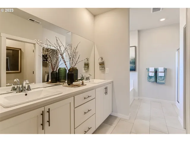 a spacious bathroom with a double vanity sink a mirror and a