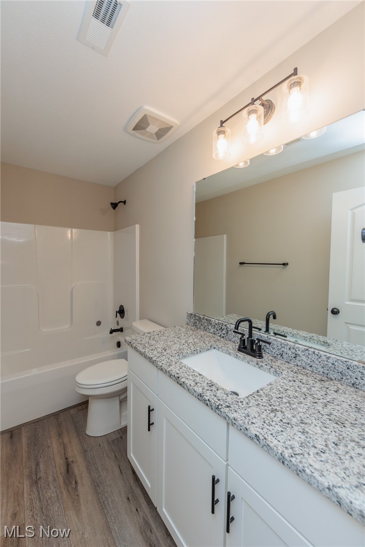 36458 Appian Way North Ridgeville, OH 44039 - Photo 24 of 37 Full bathroom with vanity, toilet, wood-type flooring, and bathing tub / shower combination