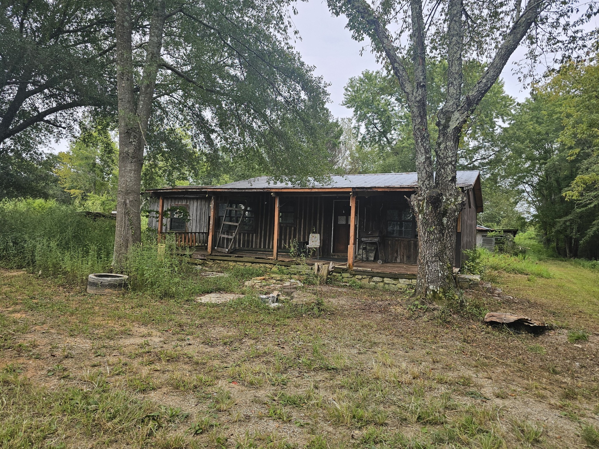 a view of a house with a yard and large tree