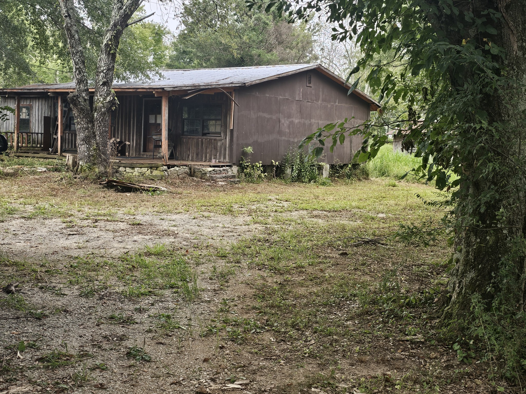 677 Howell Hill Road Flintville, TN 37335 - Photo 5 of 16 a backyard of a house with table and chairs under an large tree