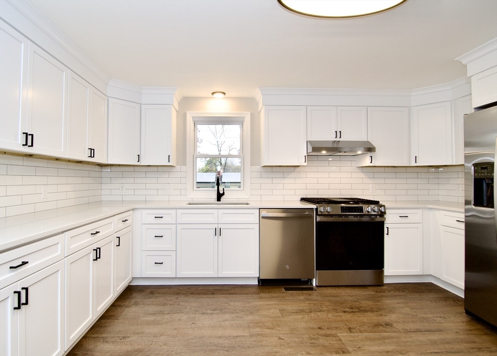 68 Sunrise Terrace Springfield, MA 01119 - Photo 13 of 42 a kitchen with stainless steel appliances granite countertop a stove a sink and white cabinets