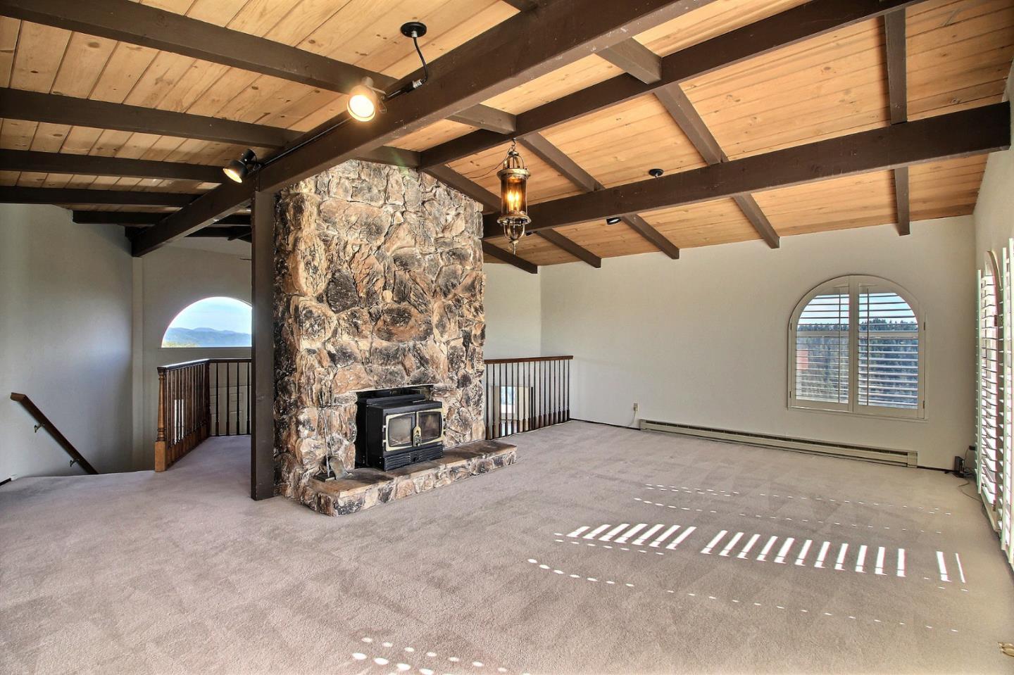16999 McGill Road Saratoga, CA 95070 - Photo 11 of 41 a view of an empty room with a fireplace and windows