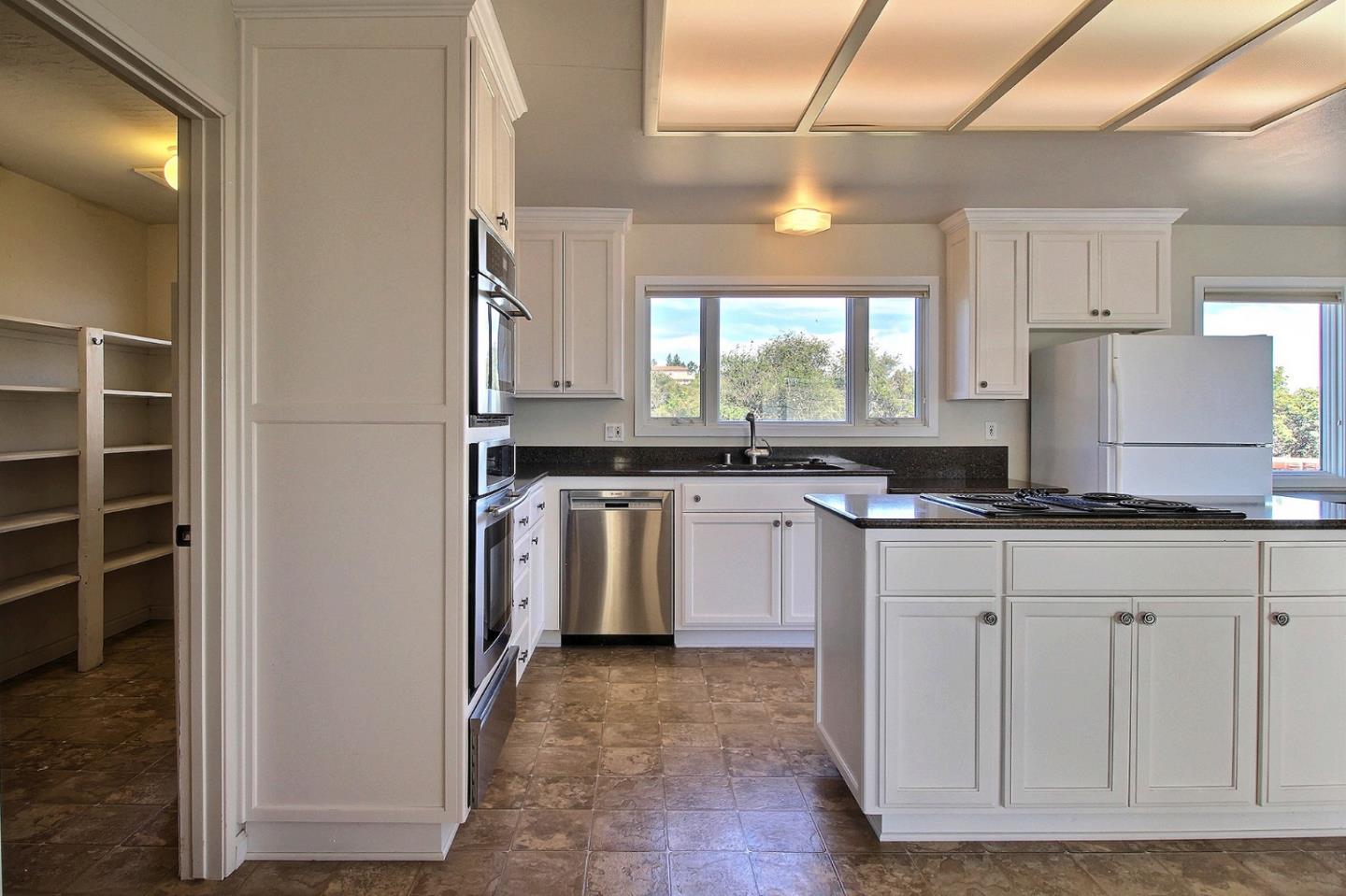 16999 McGill Road Saratoga, CA 95070 - Photo 18 of 41 a kitchen with granite countertop a sink cabinets and stainless steel appliances