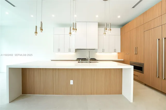 an empty room with wooden floor chandelier fan and windows