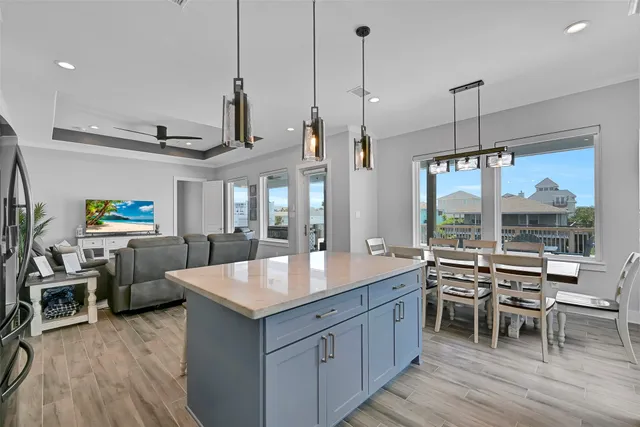 a dining room with furniture a chandelier and wooden floor