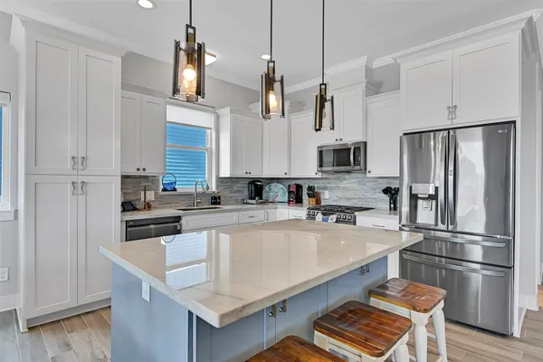 a kitchen with stainless steel appliances granite countertop a sink stove and refrigerator