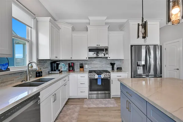 a kitchen with stainless steel appliances granite countertop a refrigerator stove and sink