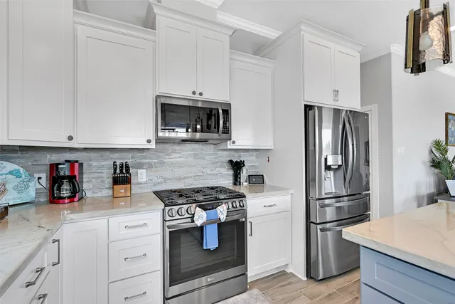 a kitchen with white cabinets and sink