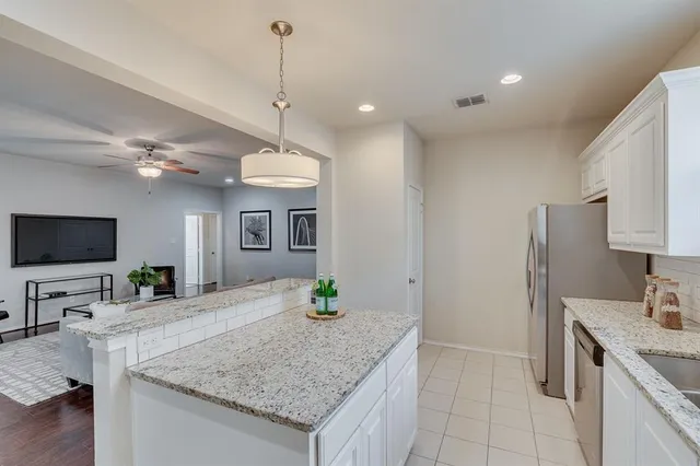 a kitchen with granite countertop a sink a counter top space appliances and cabinets