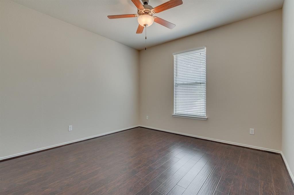 2707 McCart Avenue, Unit 209 Fort Worth, TX 76110 - Photo 21 of 25 an empty room with wooden floor chandelier fan and windows