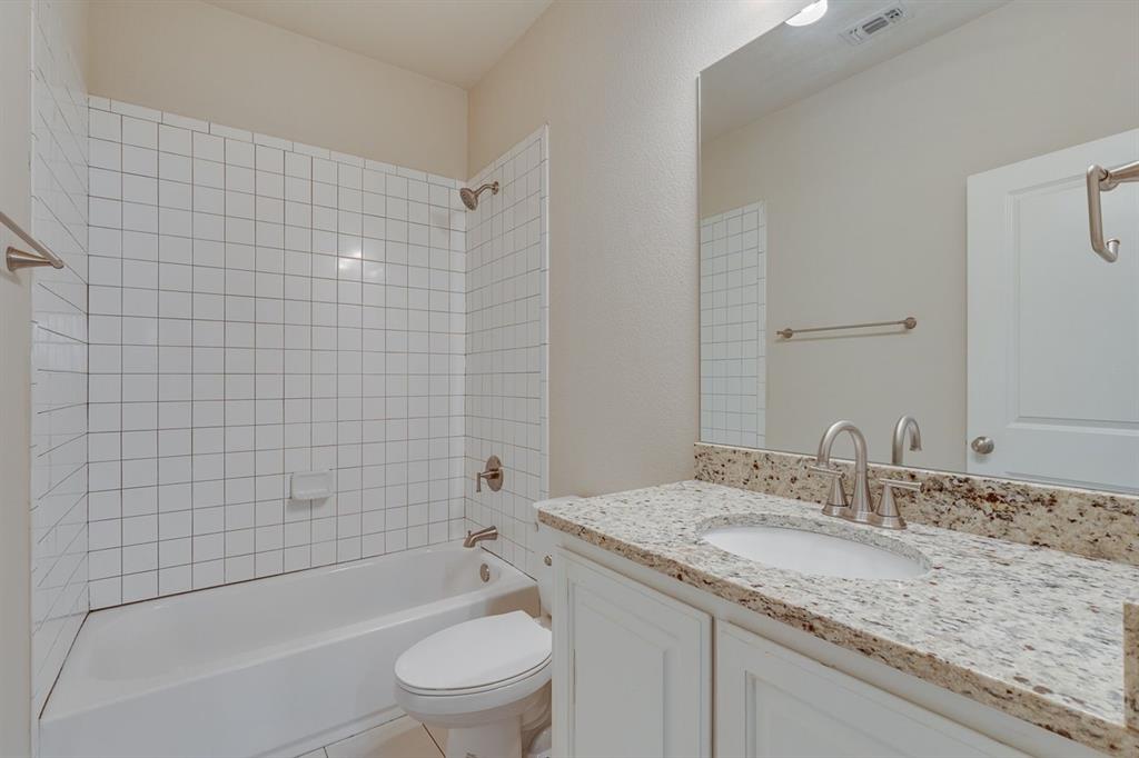 2707 McCart Avenue, Unit 209 Fort Worth, TX 76110 - Photo 24 of 25 a bathroom with a granite countertop bathtub shower sink vanity mirror and toilet