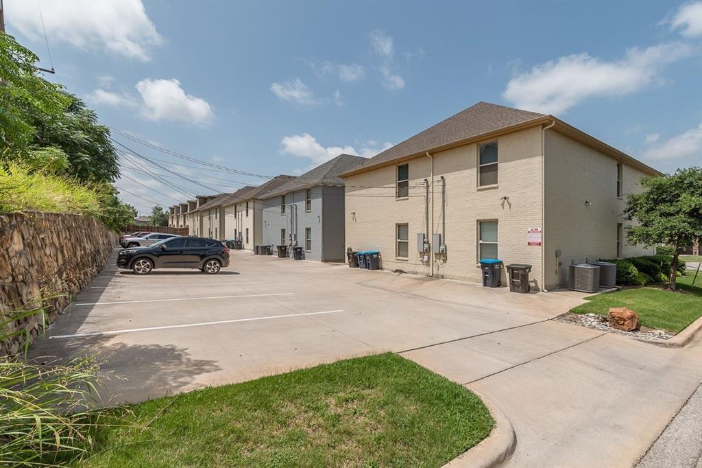2707 McCart Avenue, Unit 209 Fort Worth, TX 76110 - Photo 25 of 25 a view of a white house in front of a yard with potted plants