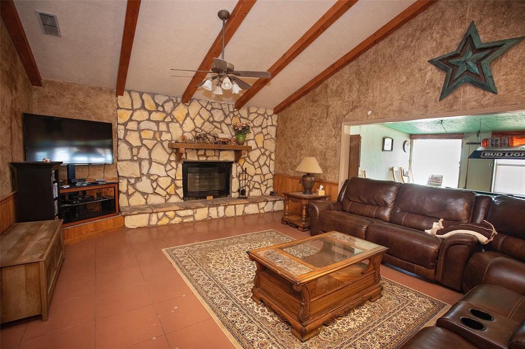 1193 Eastside Lake Road Graham, TX 76450 - Photo 24 of 38 a living room with furniture a flat screen tv and a fireplace