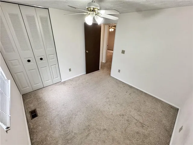 a view of a big room with chandelier fan and wooden floor