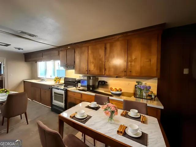 a kitchen with a table chairs stove and kitchen island