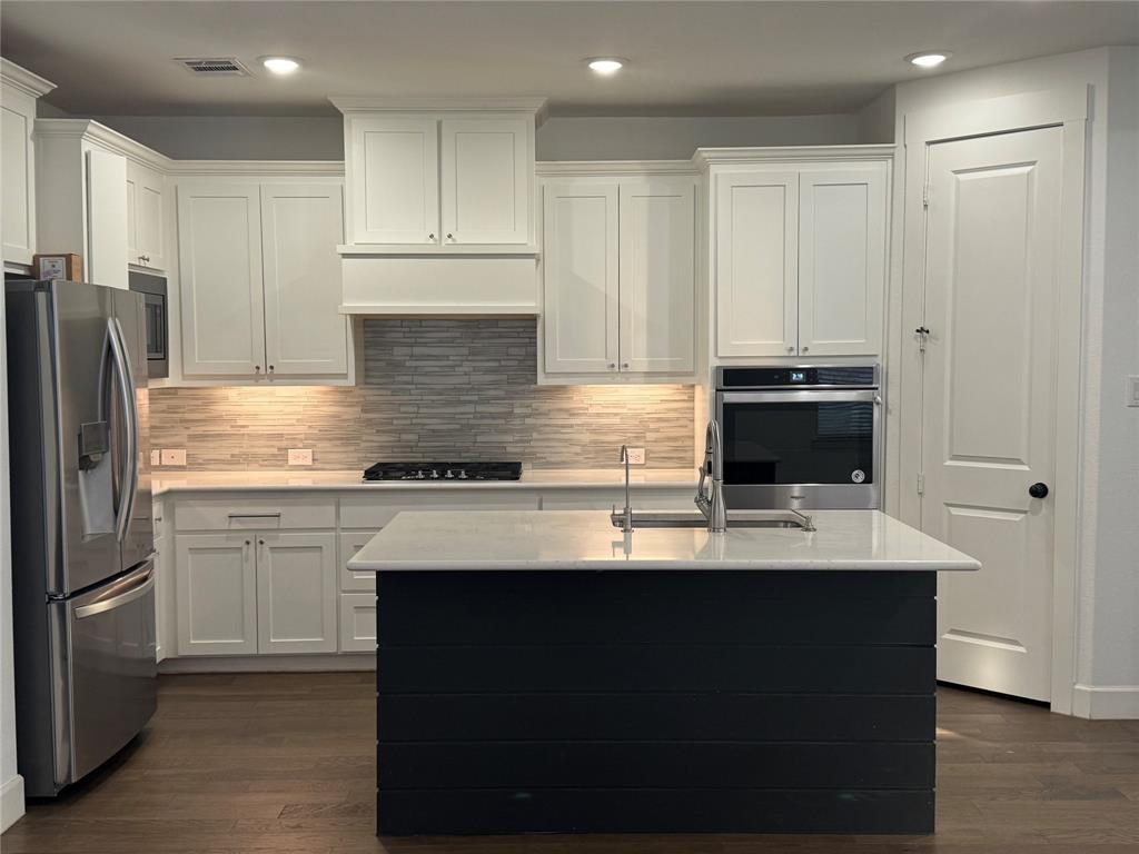 2152 Hermann Lane Carrollton, TX 75010 - Photo 7 of 18 a kitchen with kitchen island granite countertop a sink cabinets and stainless steel appliances