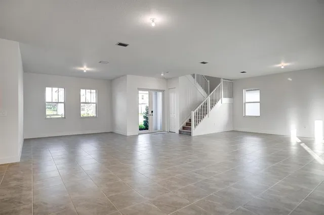 a kitchen with stainless steel appliances granite countertop a refrigerator a sink dishwasher a stove and white countertops with wooden floor