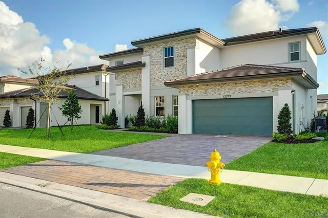 a front view of a house with a yard and garage