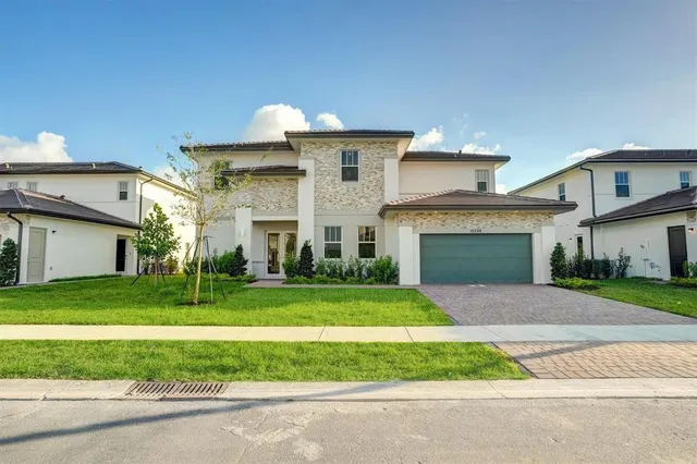 a front view of a house with a yard and garage